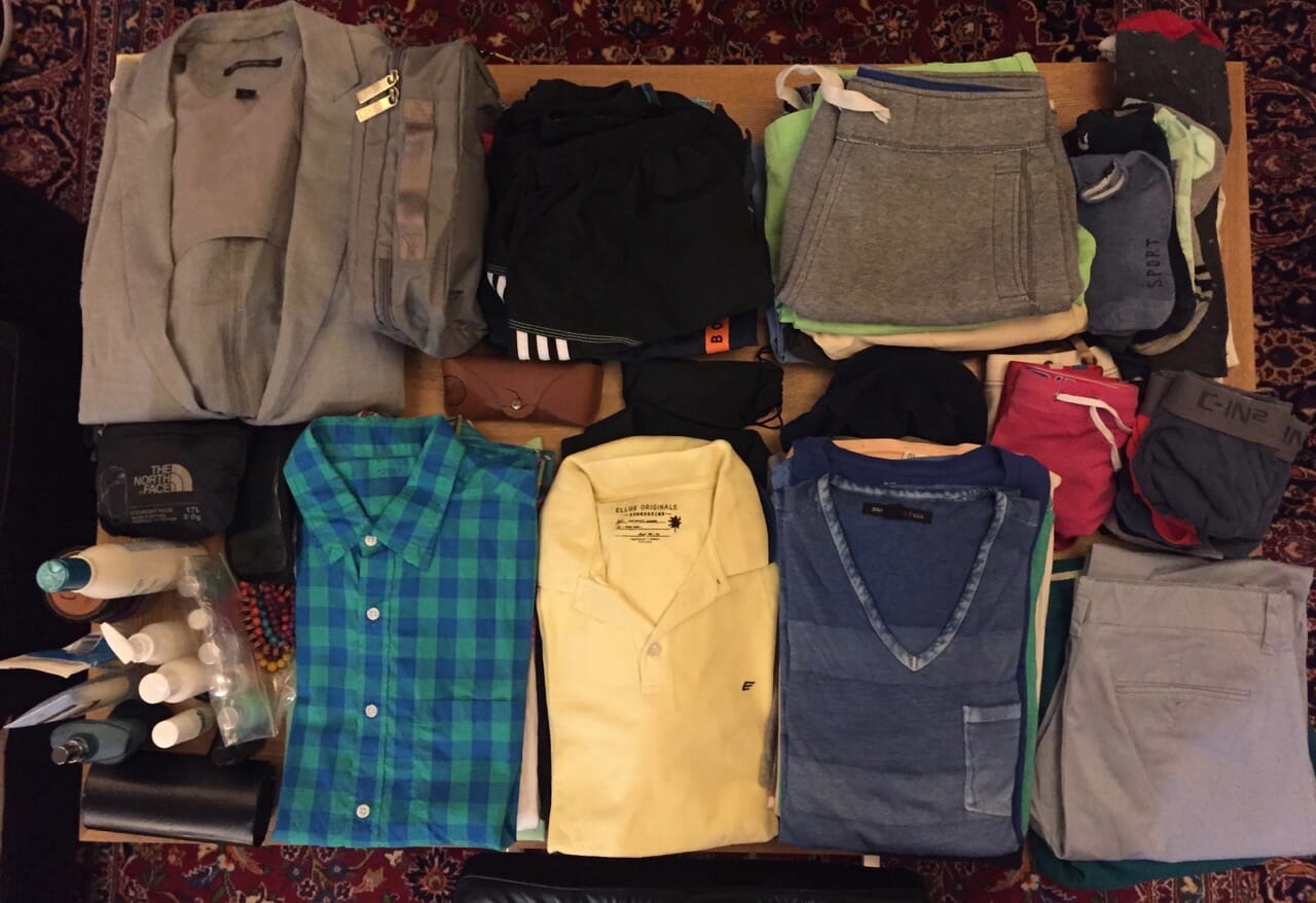 clothes placed on table to be packed in a carry-on suitcase