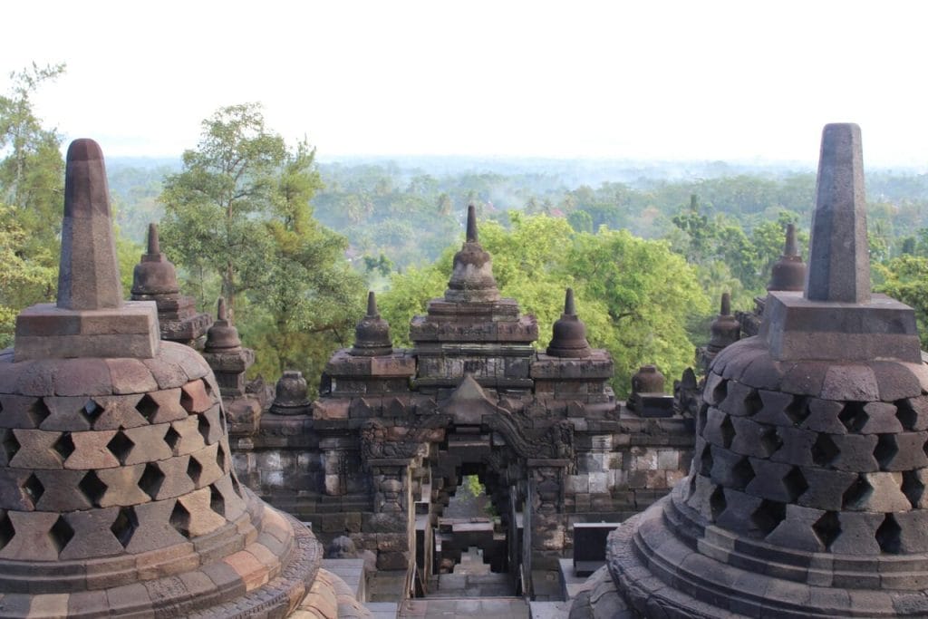 As stupas de Borobudur, que está localizado em uma área com densa vegetação na ilha de Java, aproximadamente 40Km a noroeste de Yogyakarta e 86Km a oeste de Surakarta