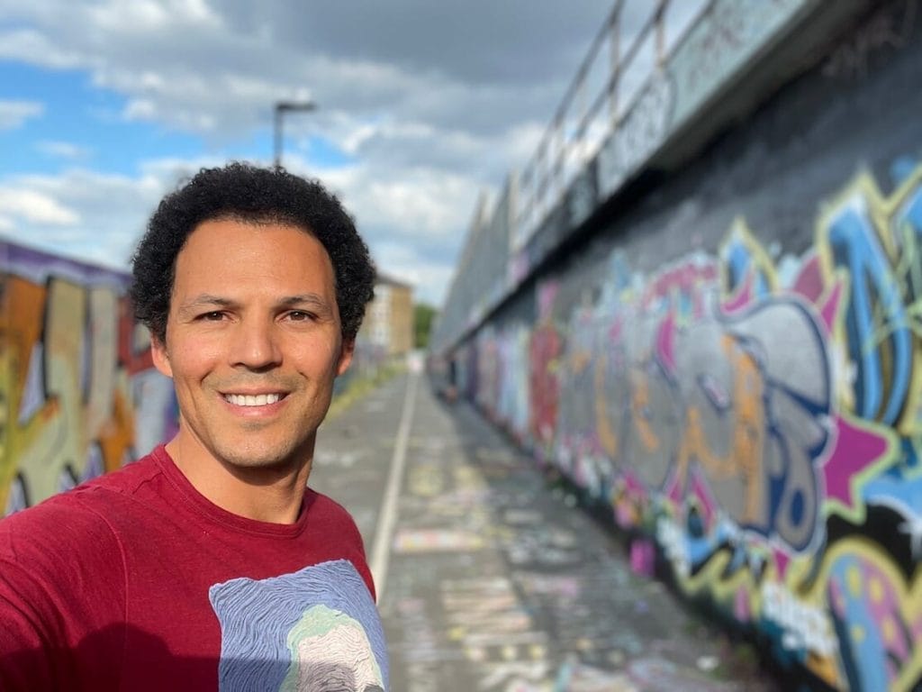 Pericles Rosa tomándose un selfie con los murales de graffiti en Shoreditch, Londres