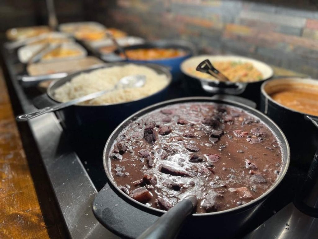 Vários tipos de comida brasileira em panelas no buffet Fogo de Chão, Londres