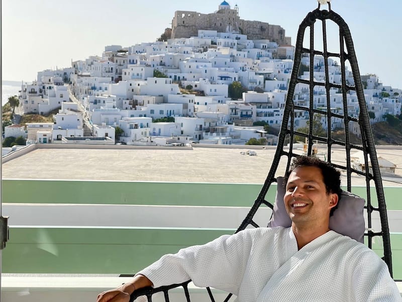 Pericles Rosa sitting on a swing chair at Anatoli Luxury Studios and Suites, Astypalea, Greece