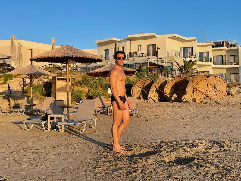 Um homem posando para uma foto na área da praia do Elia Agia Marina Hotel, Creta, Grécia