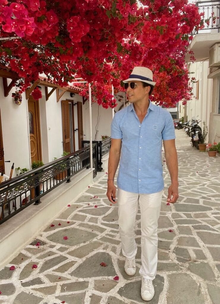 Pericles Rosa posing for a picture close to some bougainvillea flowers in Naxos Town, Naxos, Greece