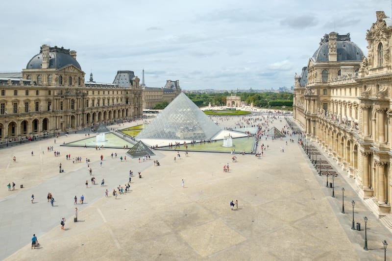 The famous Louvre Museum in Paris with the Eiffel Tower in the background